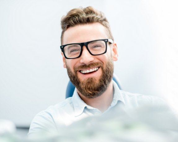 Laughing dental patient with glasses and beard