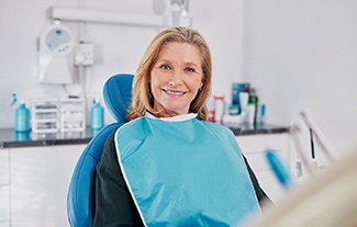 a smiling woman sitting in a dental chair