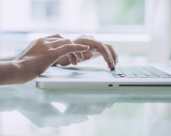 Person typing on laptop keyboard