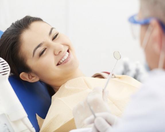 Young woman smiling right before root canal treatment