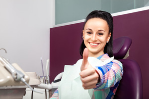 Female patient at endodontist’s office giving thumbs up