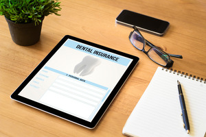 Tablet displaying dental insurance form while lying on a desk